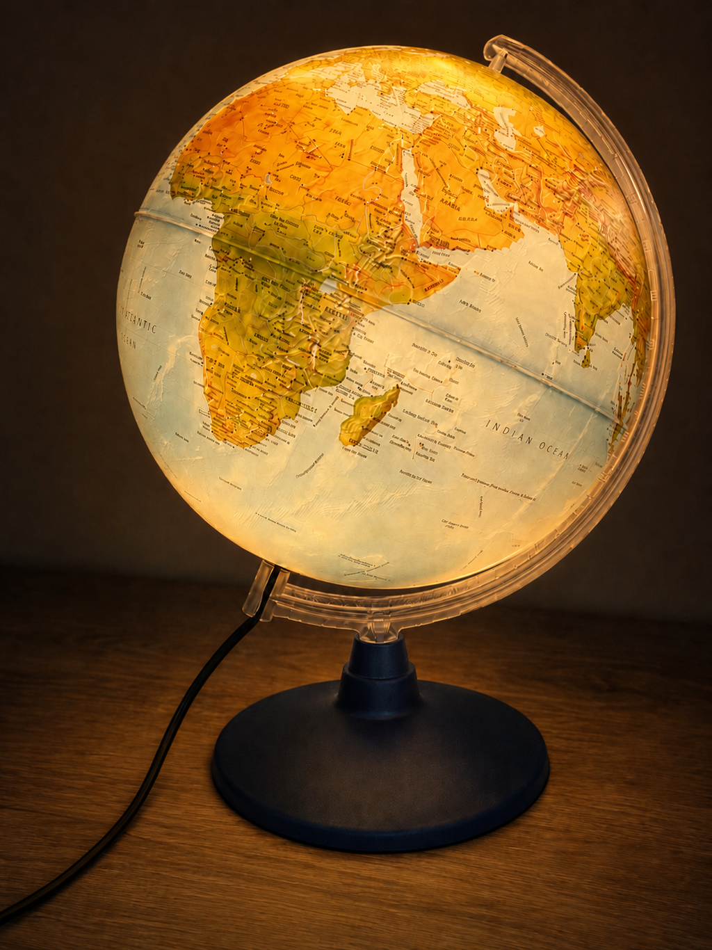 Globe with a glowing interior on a wooden surface